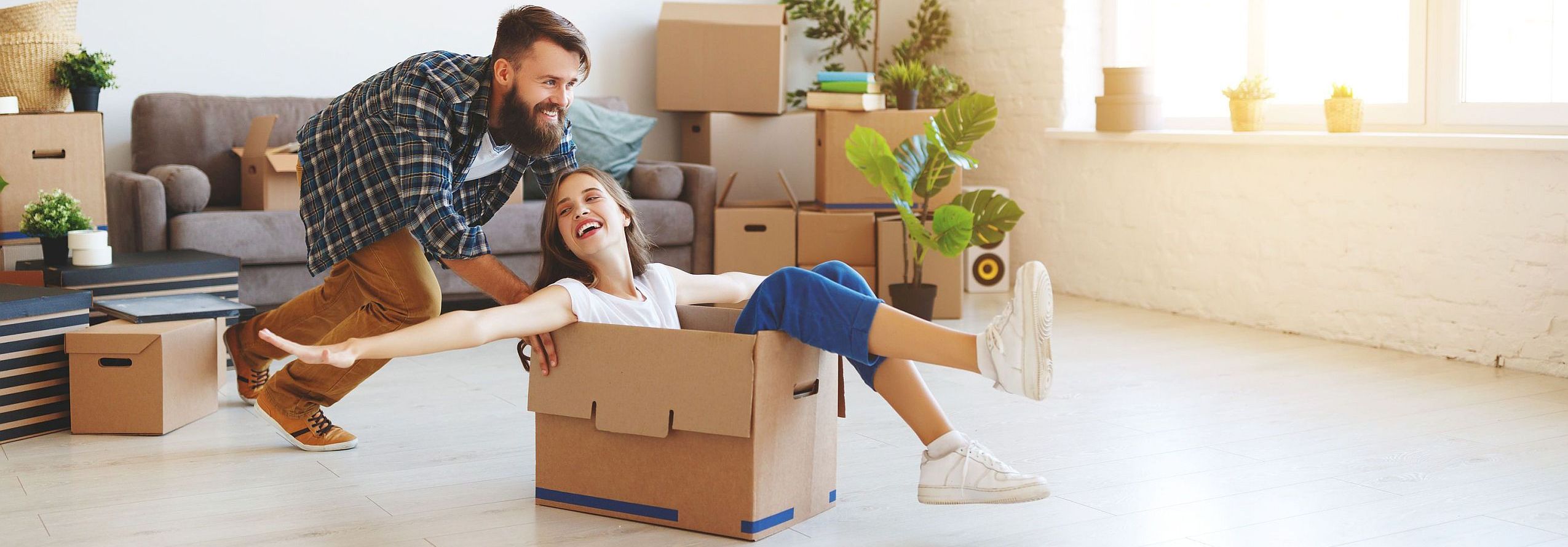 happy young married couple moves to new apartment